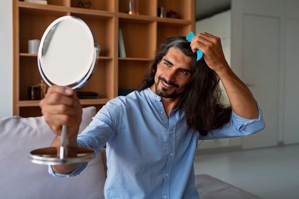 Homme de tir moyen utilisant du shampoing sec à la maison. Meilleurs conseils de soins capillaires pour les hommes