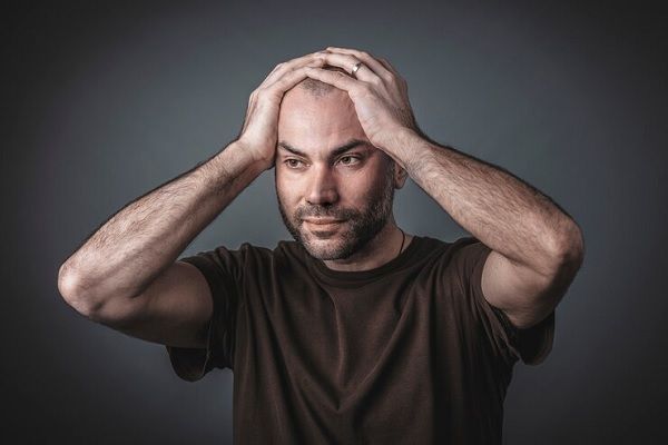 Portrait en studio d'un homme réfléchi avec ses mains tenant sa tête. Problèmes de santé mentale quotidiens chez les hommes et comment ils affectent les cheveux 