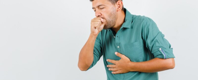 Jeune homme en chemise souffrant de toux et ayant l'air malade.. L’asthme