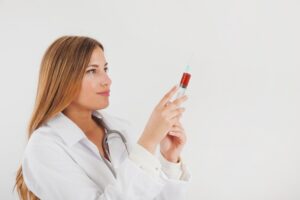 Médecin avec du sang dans un tube. Le diagnostic de l'hémophilie