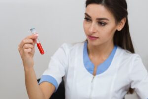 Un beau médecin examine un échantillon de sang.