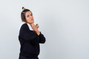 Jeune femme en pull à capuche, les bras croisés sur la poitrine, l'air séduisant