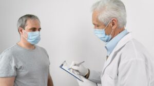 Médecin remplissant des informations sur un bloc-notes avant la vaccination d'un patient. 