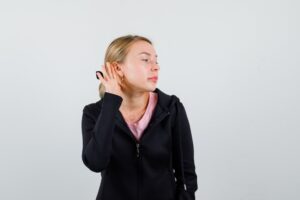 Jeune femme blonde avec une veste noire.