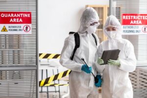 Des personnes portant des équipements de protection désinfectent une zone dangereuse. 