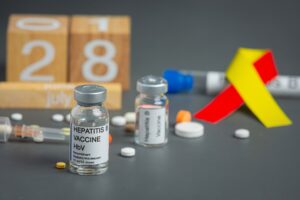 Sensibilisation à l'hépatite lors de la Journée mondiale de l'hépatite avec un ruban rouge et jaune.