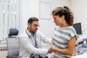 Le patient parle au médecin de sa douleur et de ses problèmes de santé.