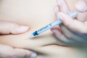 Une femme s'injecte de l'insuline dans l'estomac.
