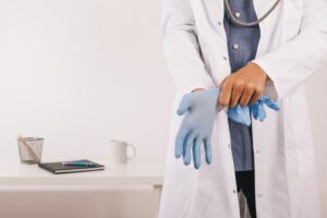 Médecin professionnel avec des gants dans son cabinet.