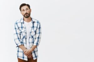 Homme mûr avec barbe, timide et peu sûr de lui, posant.