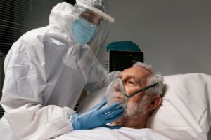 Homme âgé équipé d'un respirateur dans un lit d'hôpital. 