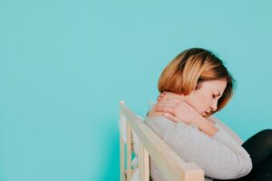Femme sur le lit avec le cou douloureux