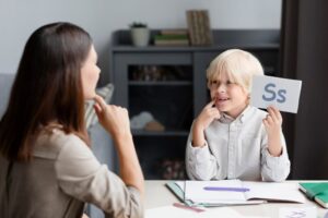 Jeune femme faisant de l'orthophonie avec un jeune enfant. Types d'hépatites