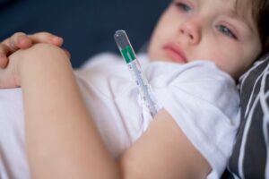 Enfant et thermomètre en gros plan. Rougeole symptômes et traitement