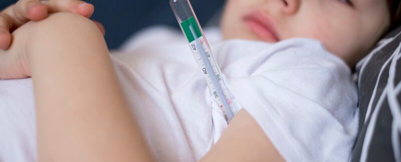 Enfant et thermomètre en gros plan. Rougeole symptômes et traitement