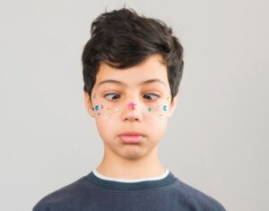 Garçon ayant des perles de maquillage sur le visage